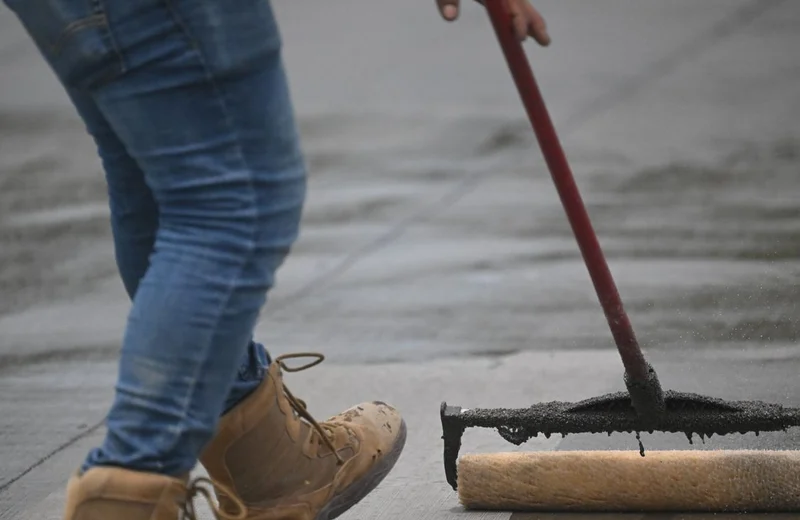Applying concrete sealer with a roller